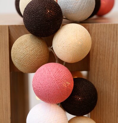 Bild av ljusslinga med dekorativa bollar i trämiljö