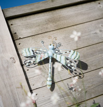 Foto: Väggmonterad trollslända i hamrad plåt utomhus