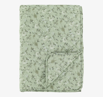 Foto av grön quiltad pläd med cremefärgat blommönster