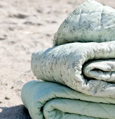 Foto: Quiltad pläd med blommor grön/creme sandstrand