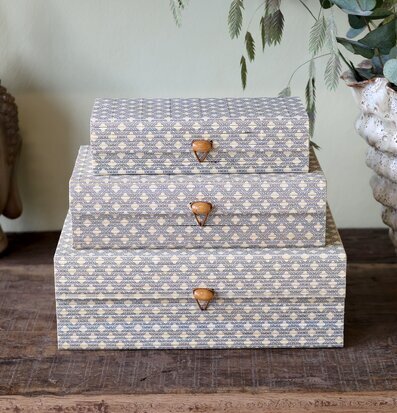 Bild på tre mönstrade förvaringsaskar i stapel på bord