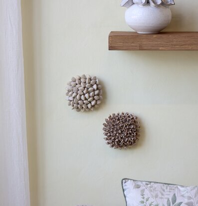 Foto: Väggdekoration korall, vas och pläd i beige