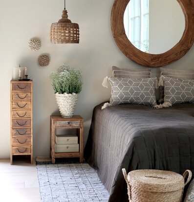 Foto: Sovrum i naturtoner med spegel och korallkruka