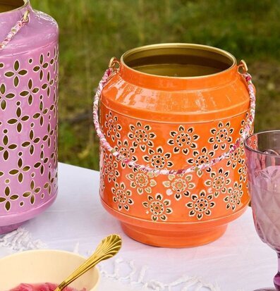 Foto: Orange metalllanterna med blommönster utomhus