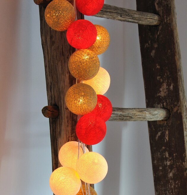 Bild av ljusslinga på rustik stege i varm atmosfär