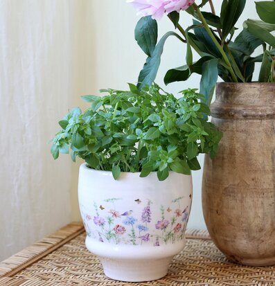 Bild: Vit kruka med blomsterband och fjärilar foto