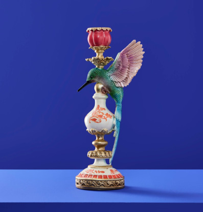 Foto av dekorativ ljusstake med kolibri på blå bakgrund