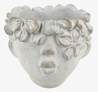 Foto: Dekorativ ansiktskruka med blomkrans, ljus yta