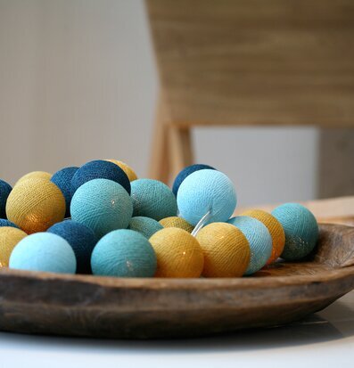 Bild av färgglada ljusbollar i rustik träskål