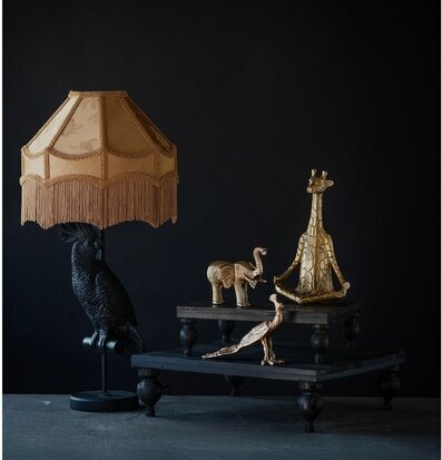 Foto stilleben med bordslampa och gyllene djurfigur