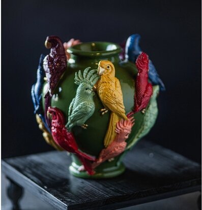 Foto: Grön keramisk vas med färgstarka papegojor