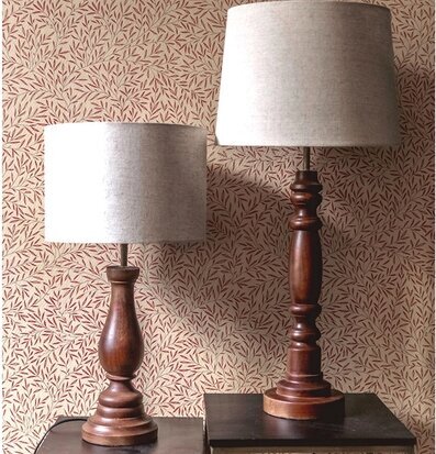 Bild: Två bordslampor i trä mot mönstrad tapet