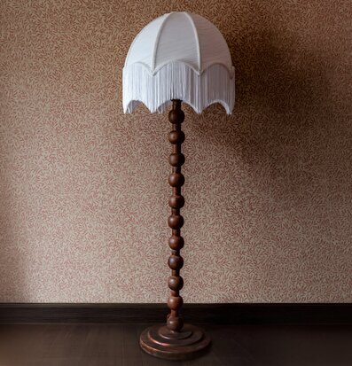 Foto av mörkbrun golvlampa med fransad skärm