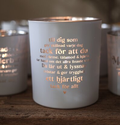 Foto: Vit ljuslykta med koppartext och tackbudskap