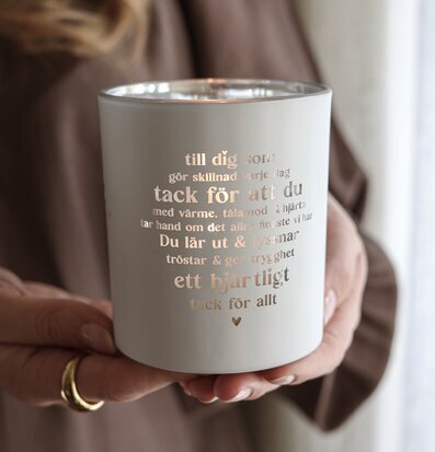 Foto: Person håller ljuslykta med tack-text och hjärta