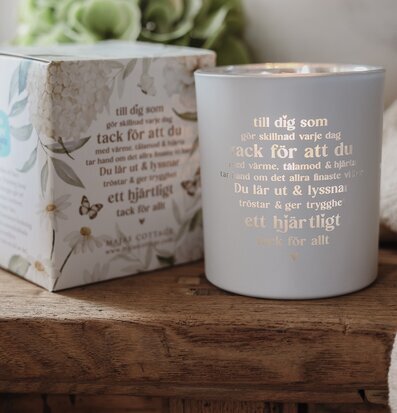 Foto: Ljuslykta med tacktext och blomförpackning