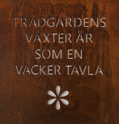 Foto rostig metallskylt med text Trädgårdens växter är
