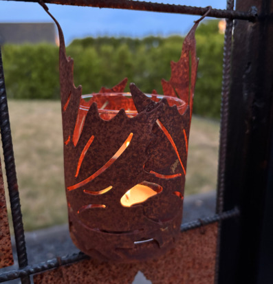 Foto av rostig lykta med lönnlöv och värmeljusglas