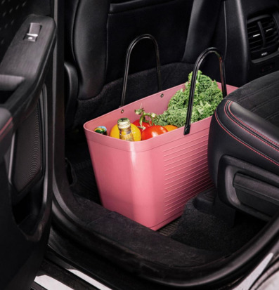 Foto: Varmrosa plastväska med matvaror i bilbaksäte