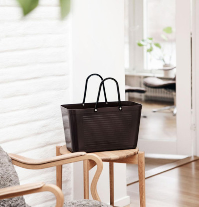 Foto: Brun väska på träbord i ljus hemmiljö, stående