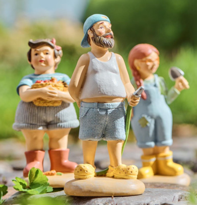 Foto: Trädgårdsfigurer med slang och korg utomhus