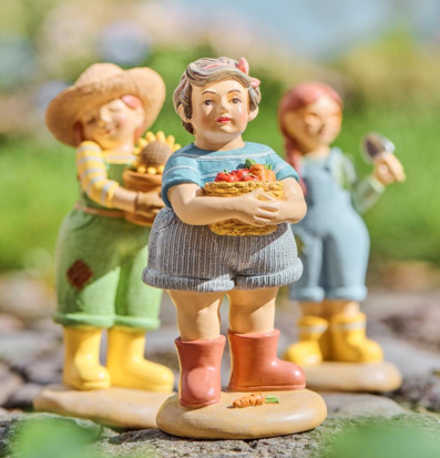 Foto: Trädgårdsfigurer med korgar på stenlagd gång