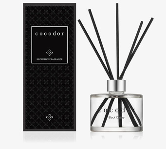 Foto: Doftpinnar med glasflaska och svart ask vit bakgrund