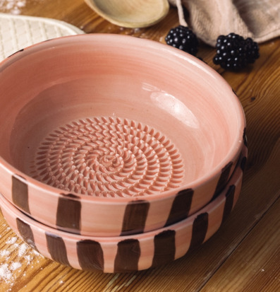 Foto: Rosa keramisk rivskål med spiral på träbordet