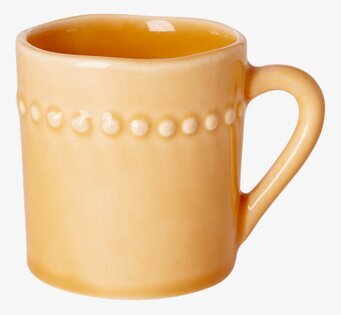 Foto av orange keramikkopp med unik design och detaljer