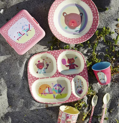 Bild av lekfulla barnprodukter i somrig picknickmiljö