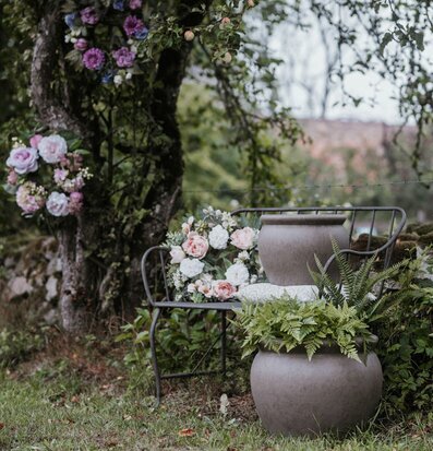 Foto: Stora krukor med ormbunke och rosor i trädgård