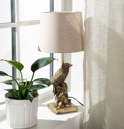 Foto: Bordslampa med fågelfot vid ljust fönsterparti
