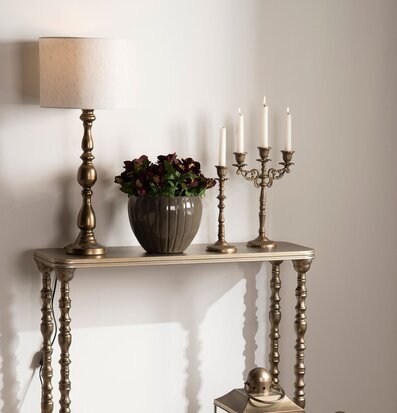 Foto: Konsolbord i mässing med lampa och ljuslyktor