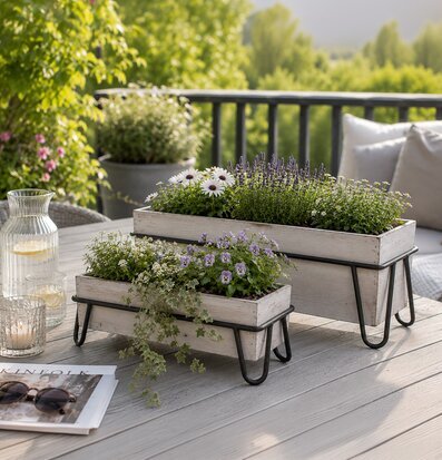 Foto av blomlådor på bord med somrig uteplatsmiljö