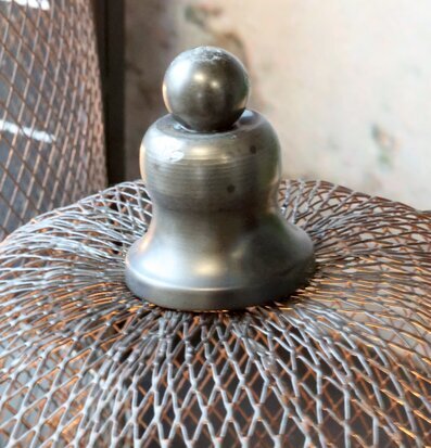 Foto: Antikgrå ljusklocka med metallnät, närbild