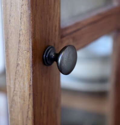 Foto: Närbild på skåpdörr i naturträ med metallknopp