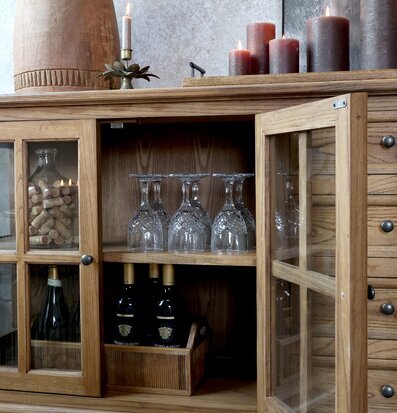 Foto: Vitrinskåp i naturträ med glas, ljus och korkar