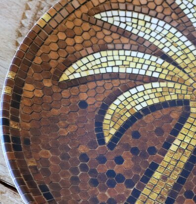 Foto: Närbild av mosaiktallrik i brunt, vitt, gult