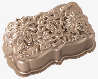 Foto av metallbakform med blomrelief frilagd vit bakgrund