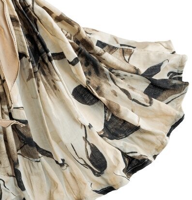 Foto på draperat tyg med bladmotiv i beige svart