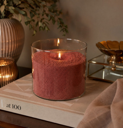 Foto: Ljussand i glas med två tända vekar, rosa ton