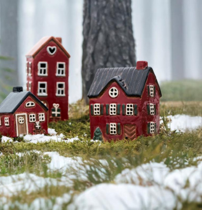 Foto: Röda huslyktor i vintrig miniatyrby i skog
