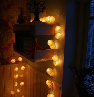 Bild av mysigt rum med ljusslinga och dekorativa element