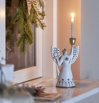 Foto: Änglaljusstake med tänt ljus vid fönsterbänk