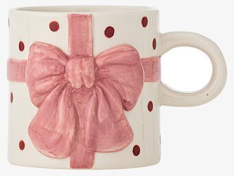 Foto av ljus mugg med rosa rosett och prickar