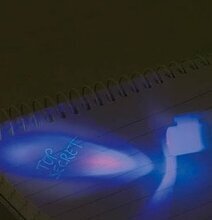 Bild av anteckningsbok med osynligt bläck i blått ljus