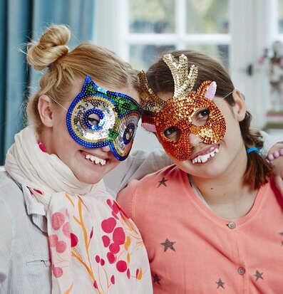 Bild av barn i färgglada masker och lekfull klädsel