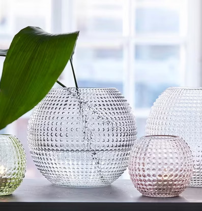 Bild av glaslyktor med prickigt mönster och växtarrangemang