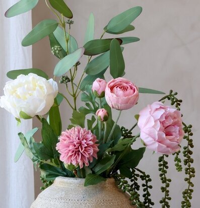 Foto på rosa och vita konstblommor i kruka, närbild