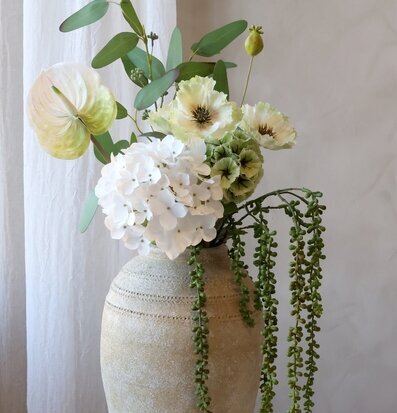 Bild på konstblommor i kruka med grönt pärlband